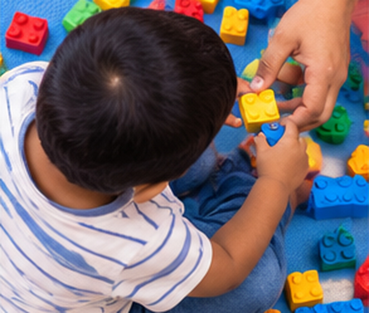 A toddler reaching for building blocks on the floor